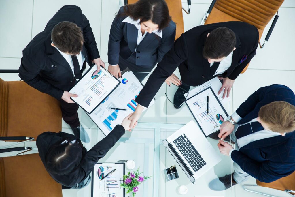 top view - handshake Manager and Finance Director after approval of the financial plan of the company in the workplace